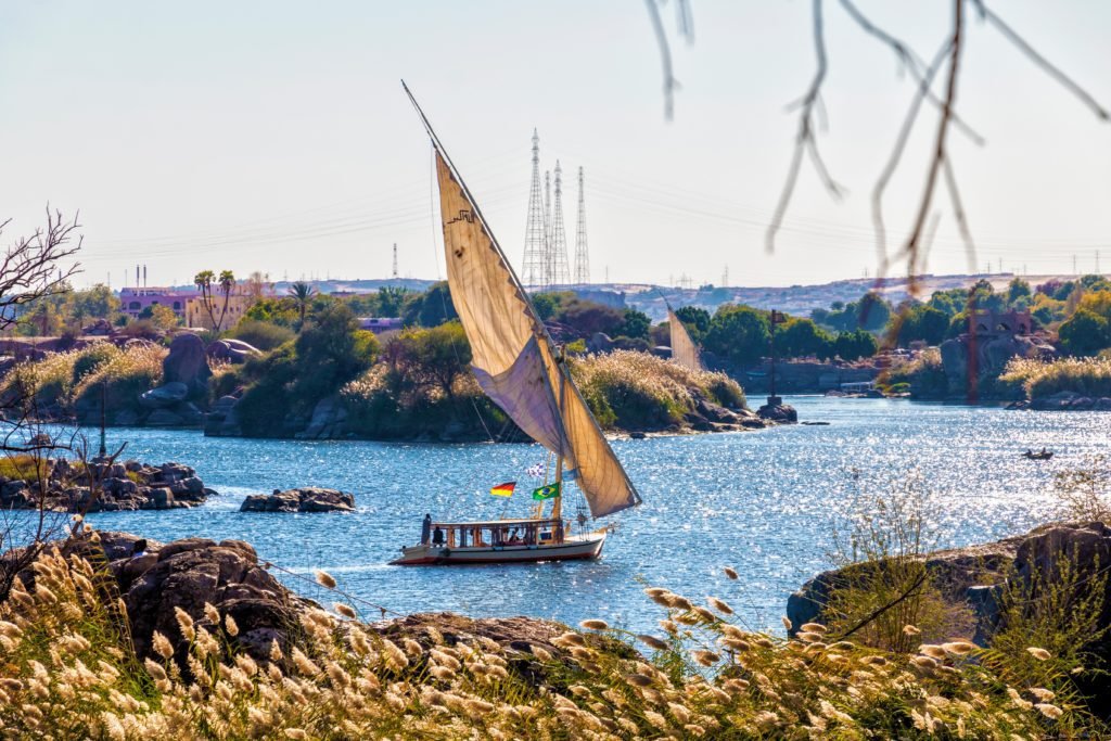 Feucca on the river Nile with half sail. Power lines in the backgorund
