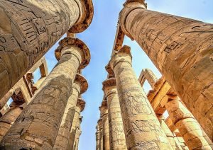 Image of the columns in Karnak Temple. Taken form the ground looking up towards the sky. Clear blue sky in the back ground.