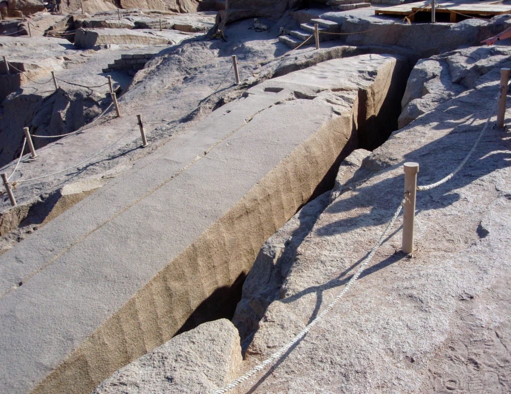 image of an obelisk still in the quarry. a crack is located at the 1 oclock position and travels towards the 7 oclock position.