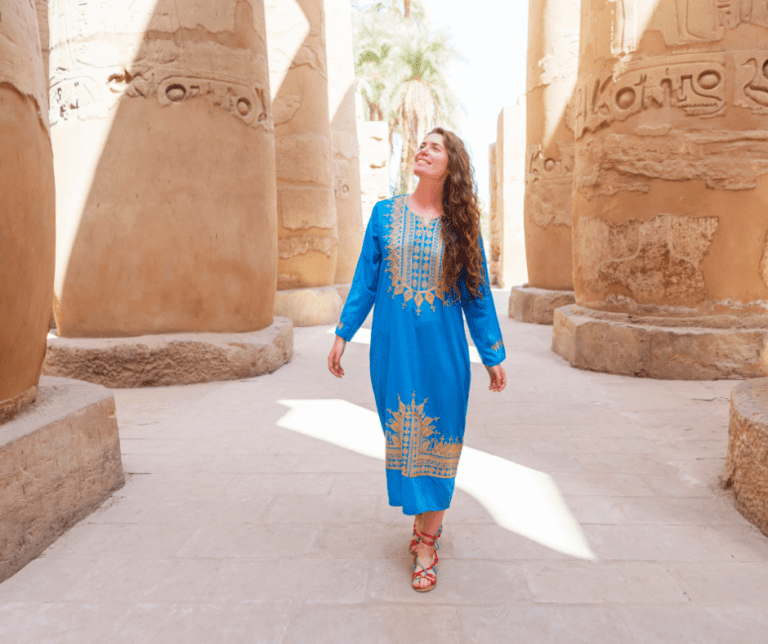 Female walking between the Columns in the Temple of Karnack, Luxor Egypt